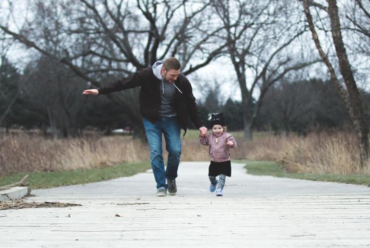 Adult and child running outdoors in winter